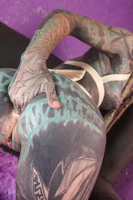 Сильно татуированная девушка Anuskatzz сжимает кулаками свою зияющую задницу во время сольного действия