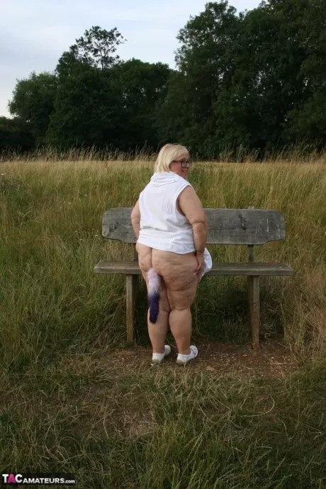 Толстая британская леди Лекси Каммингс обнажает себя на скамейке в поле